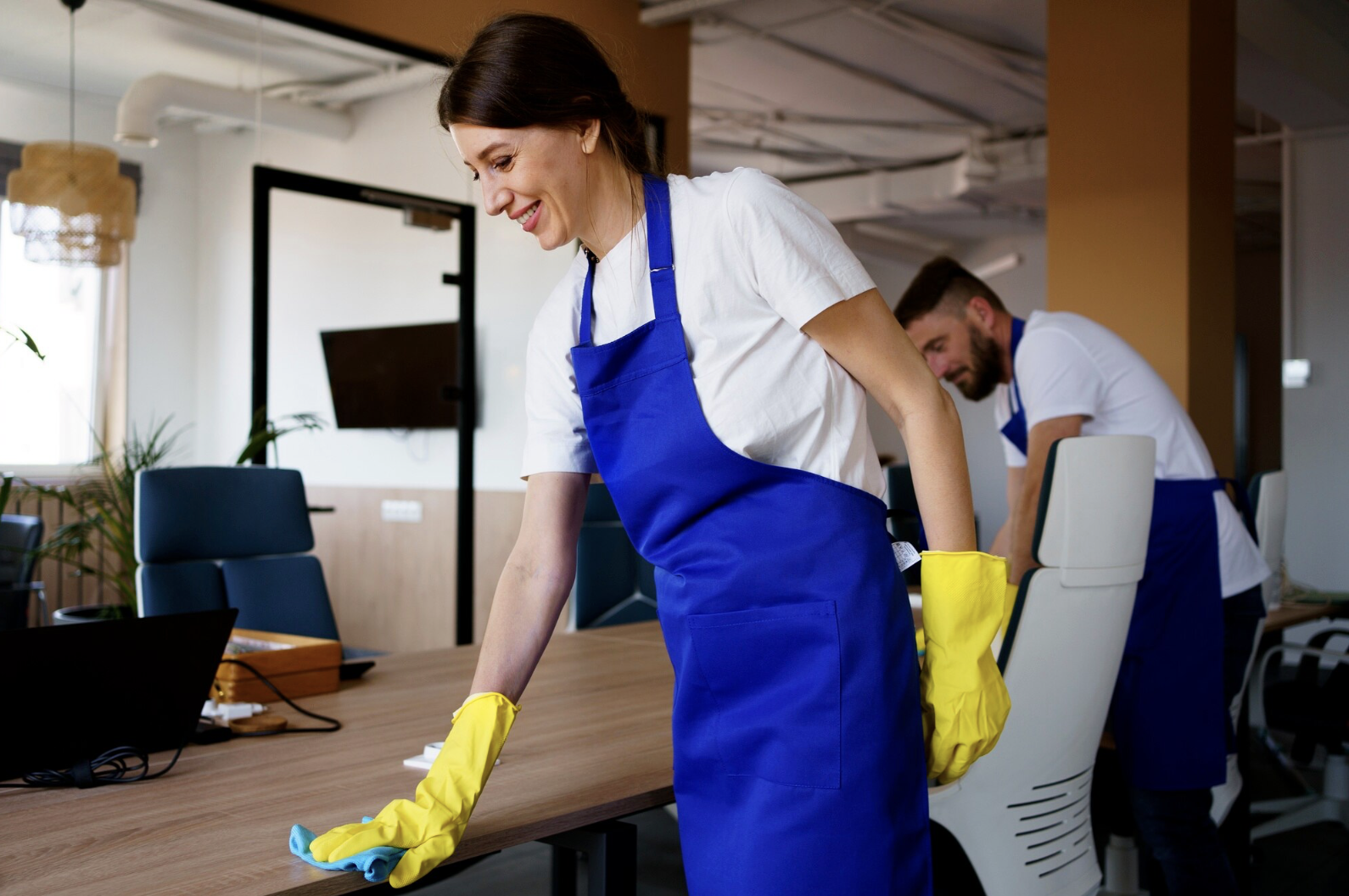 Man en vrouw die een kantoorbureau schoonmaken namens Cleaning Service Eindhoven